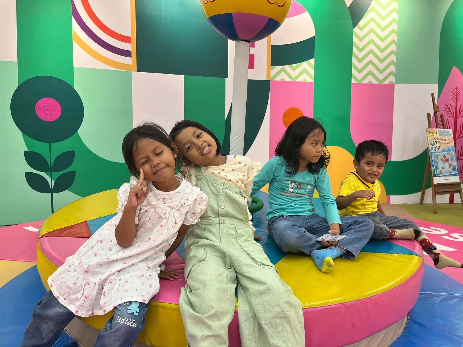 Empat anak asuh tersenyum dan berpose ceria saat rekreasi di area bermain