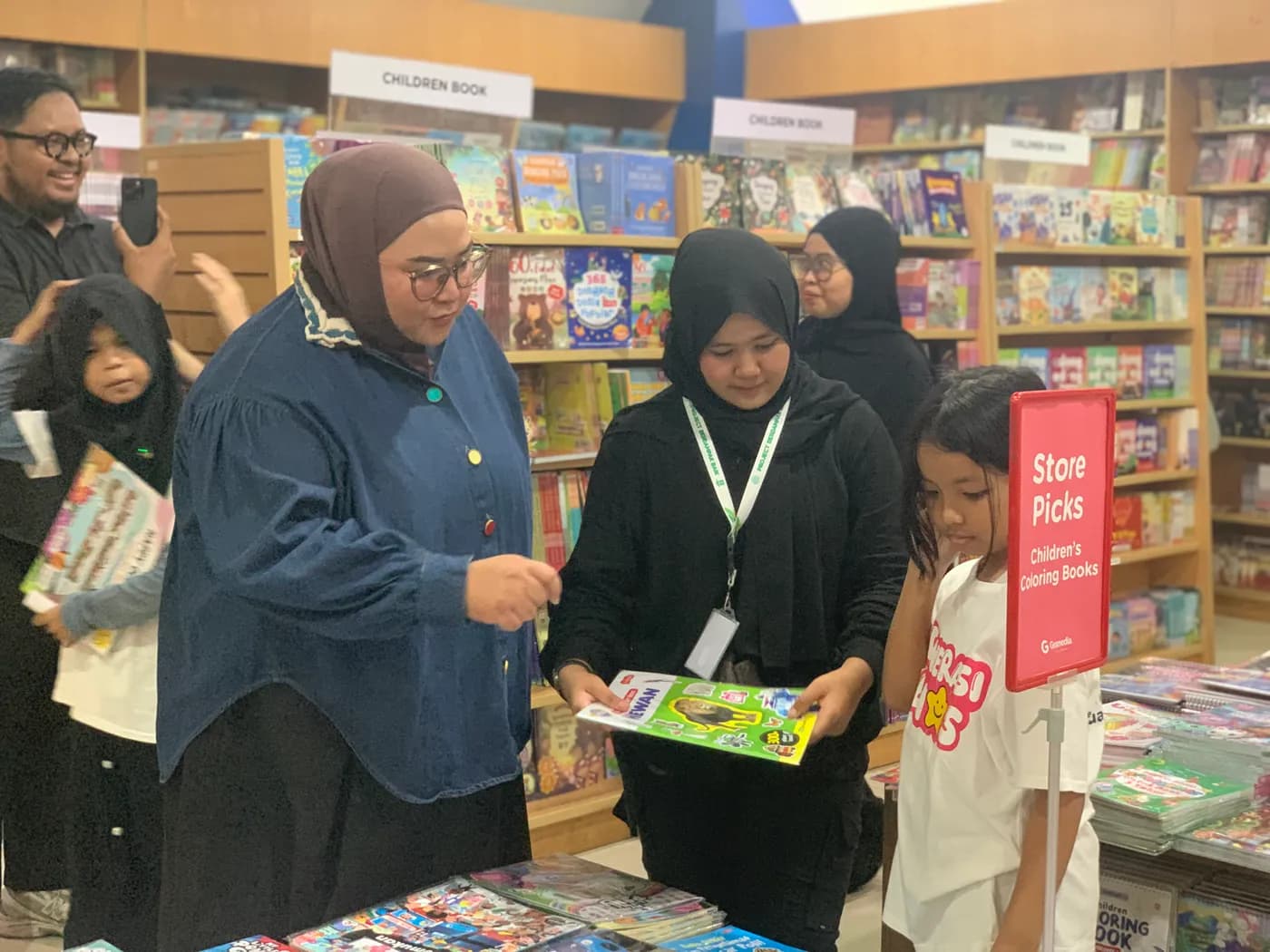Anak-anak asuh memilih buku bacaan didampingi relawan di toko buku